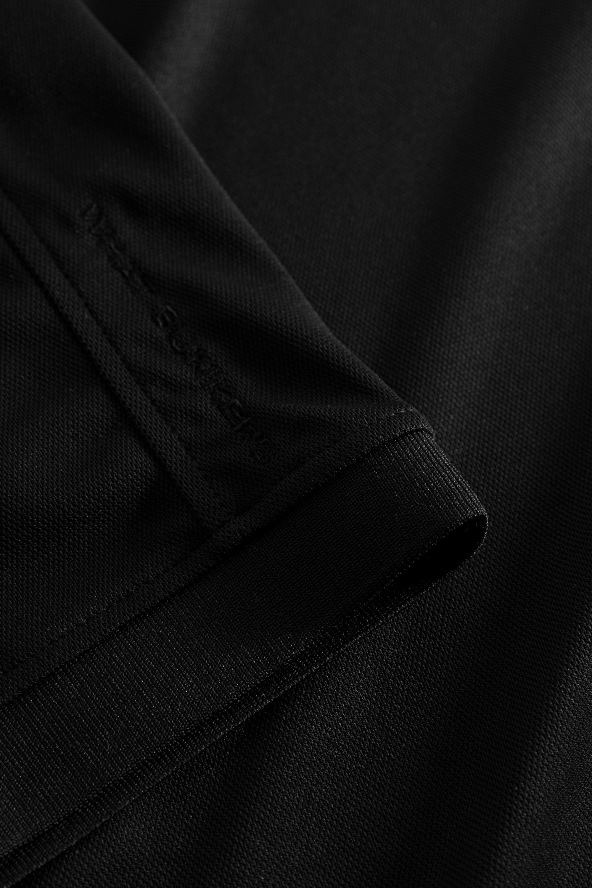 Black golf polo shirt with WHAT BUNKERS details. 